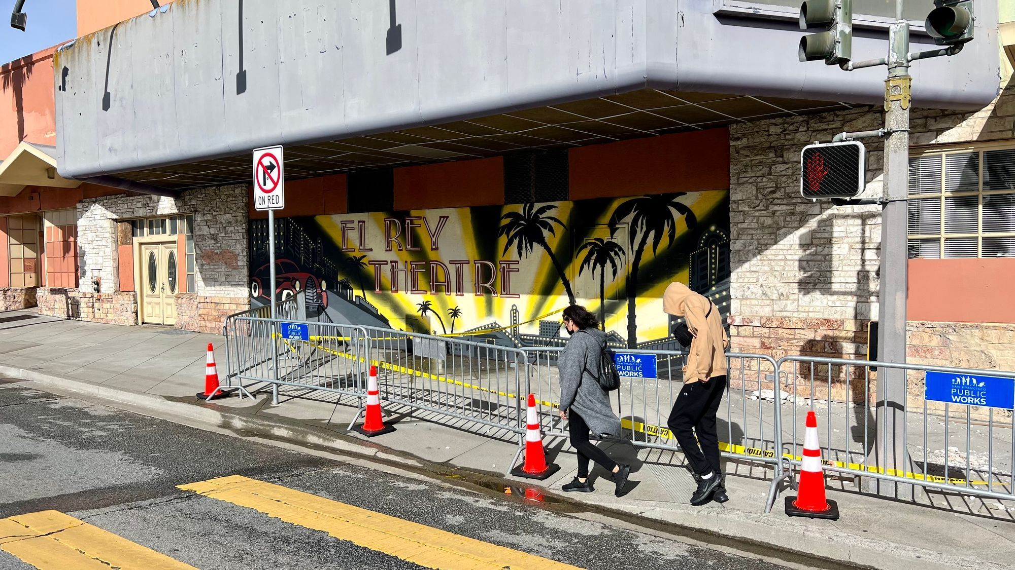 Pedestrians walk near fallen plaster