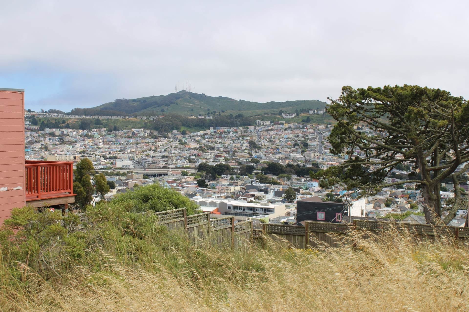 Open space in the foreground with hillsides full of homes in the background.