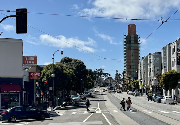 A streetscape with a theater's tower in scaffolding.