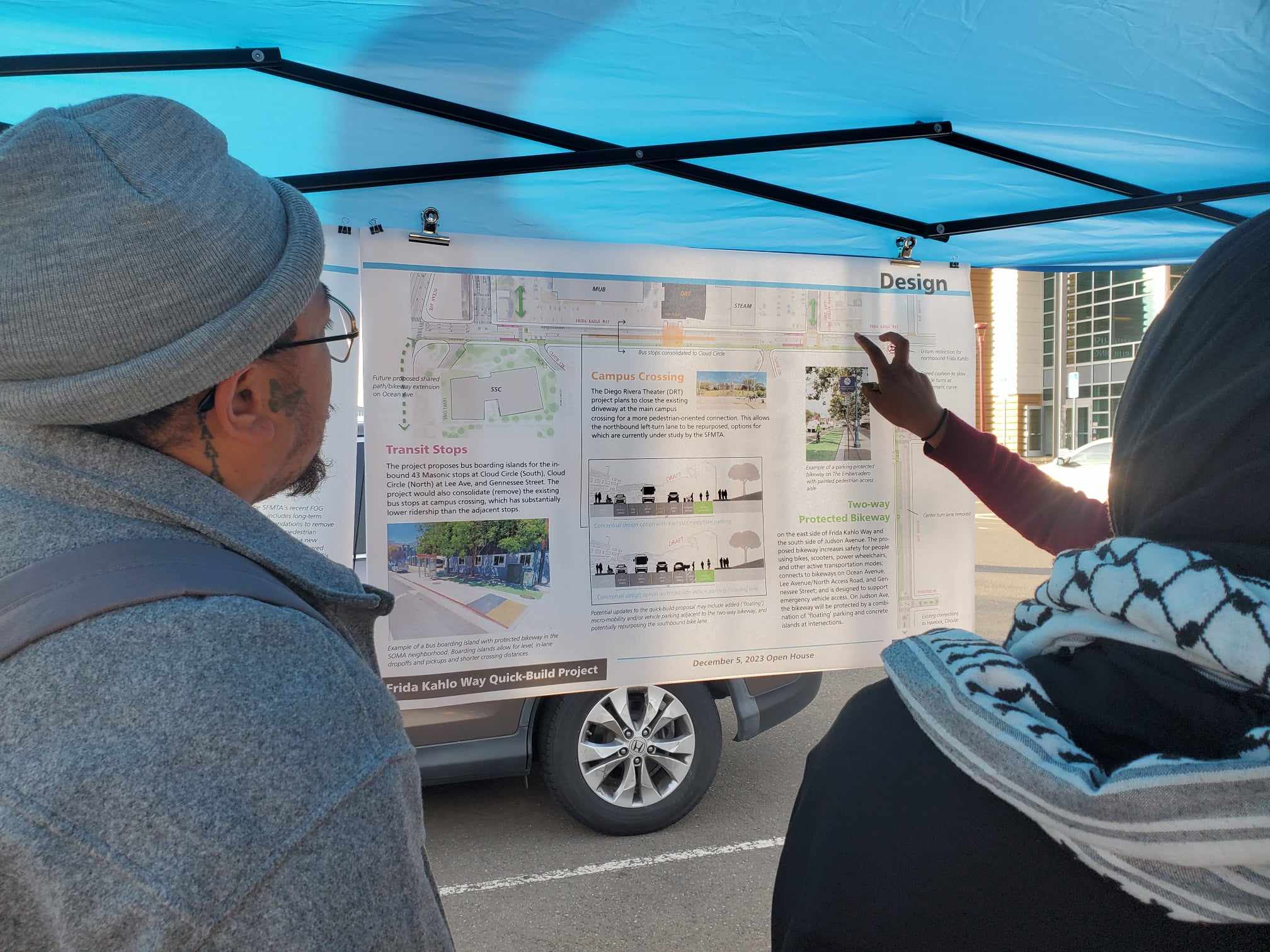 Two visitors look at plans for the Frida Kahlo Quick-Build Project.