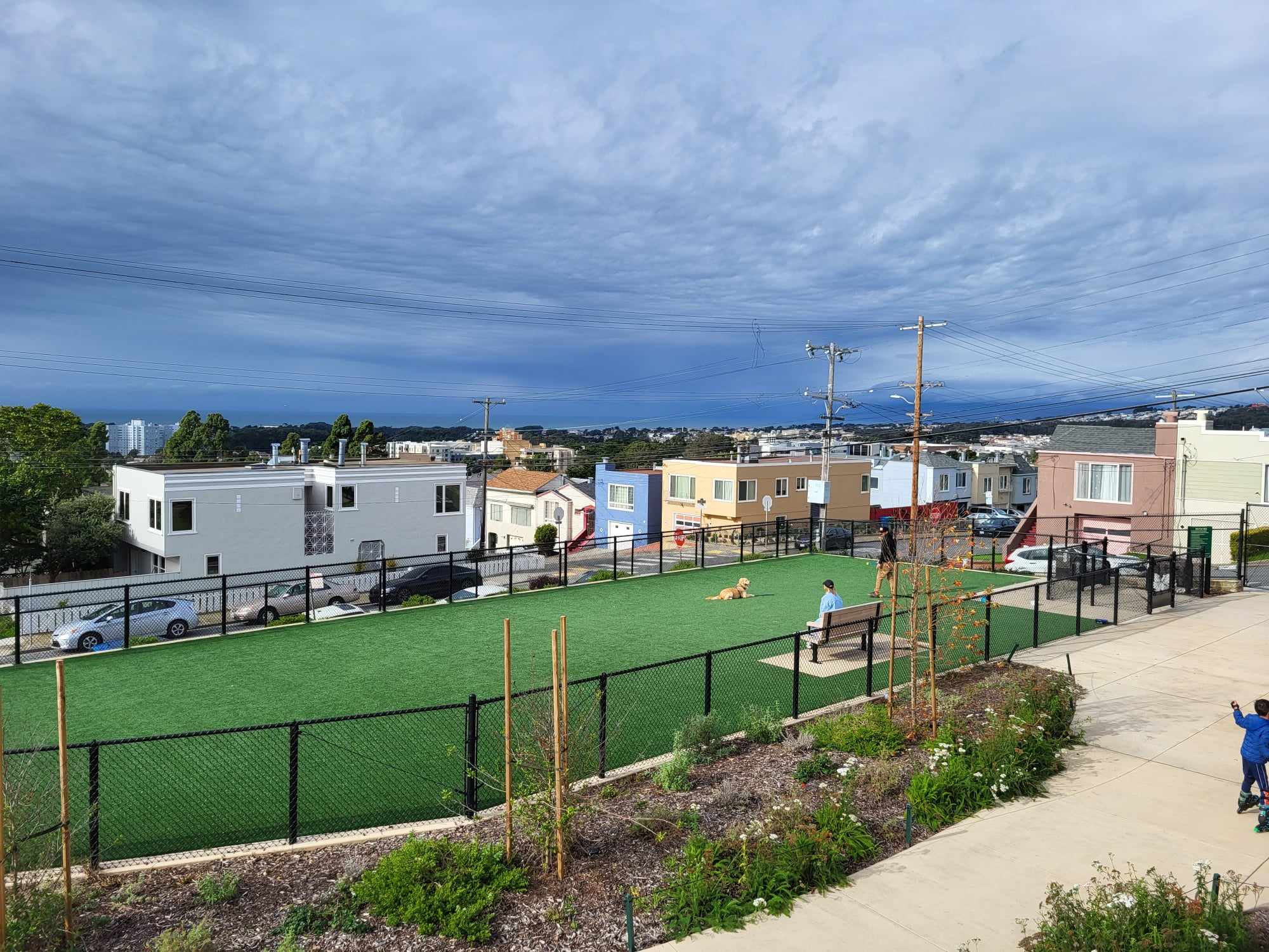 Park with houses and sky in the distance.