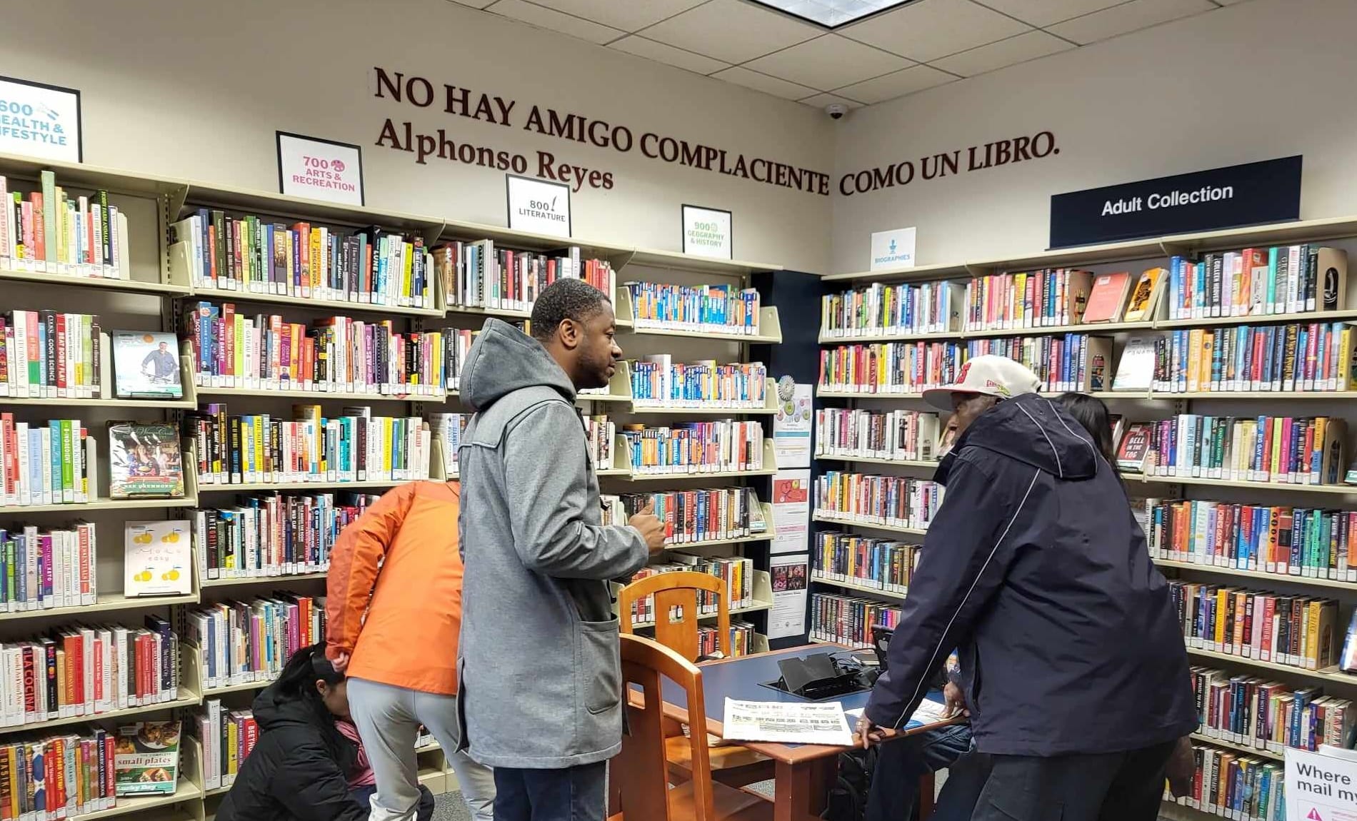 People speak inside the stacks of a library.