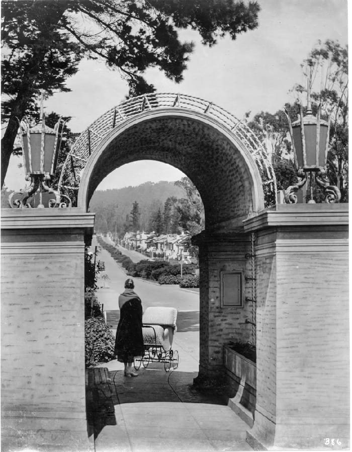 Woman stands outside of entrance gateway