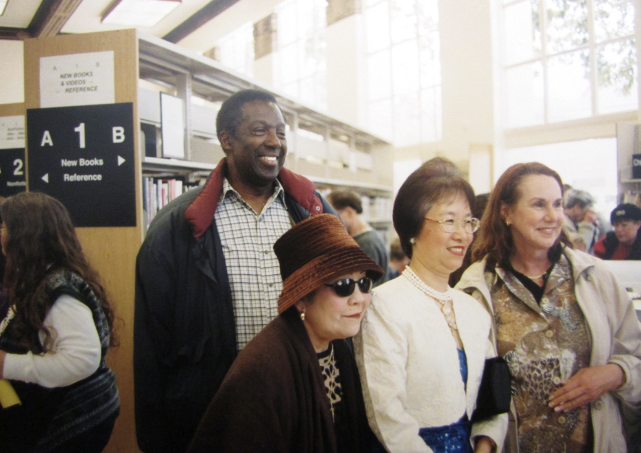 People pose for a photograph inside a library.