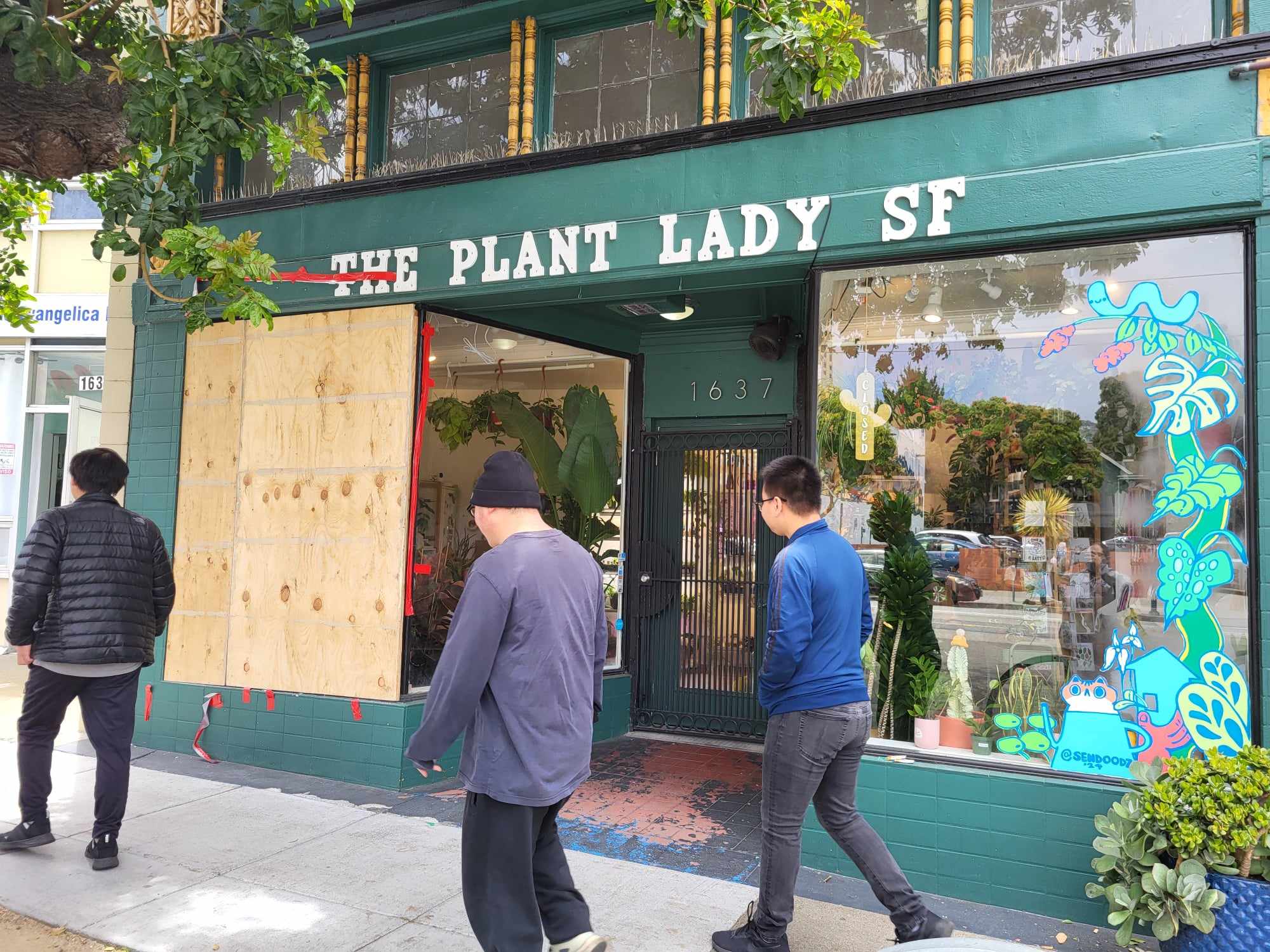 Storefront covered with plywood.