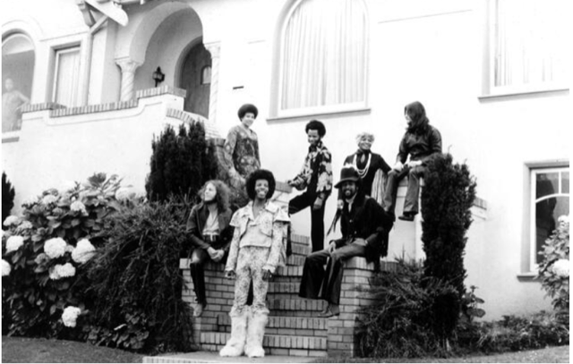 A band stands outside a home.