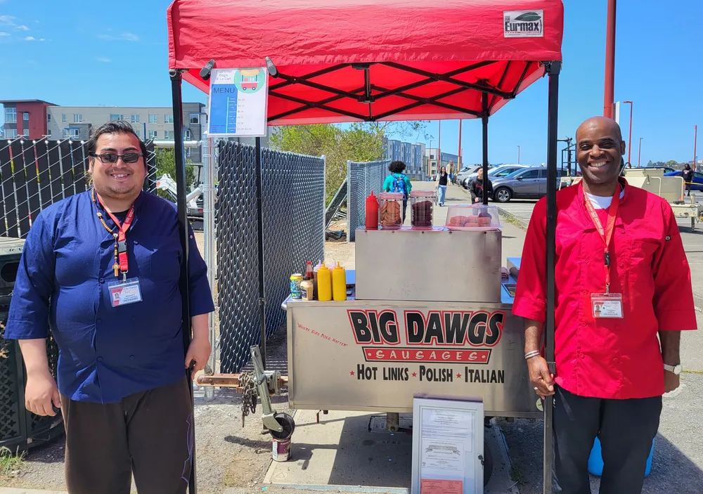 Men at hot dog cart.