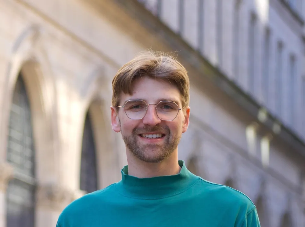 Man posing in green mock neck.