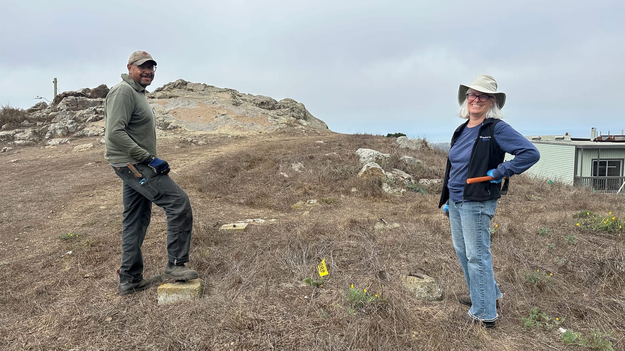 Two people holding tools in the park.