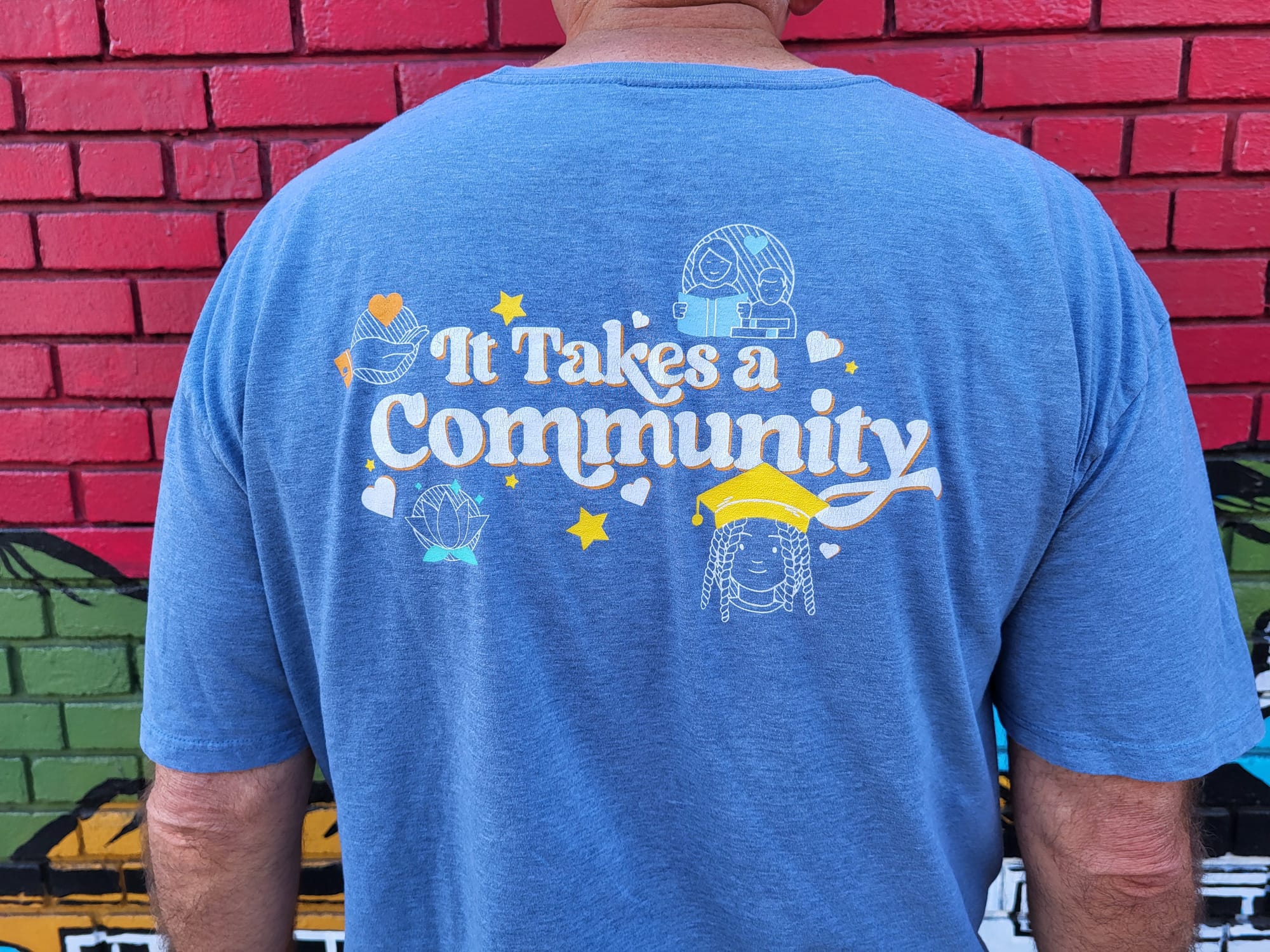 Shirt reading "It Takes a Community."