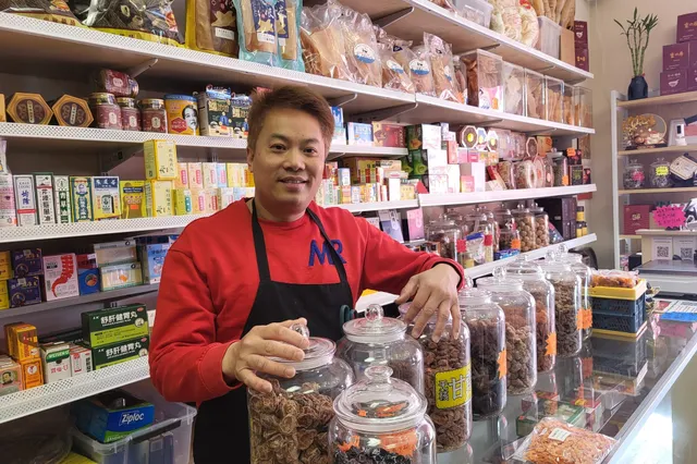 Man at a counter with herbs.