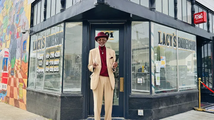Man outside barbershop.