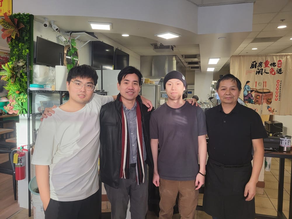 Four men post for a photo in a restaurant.