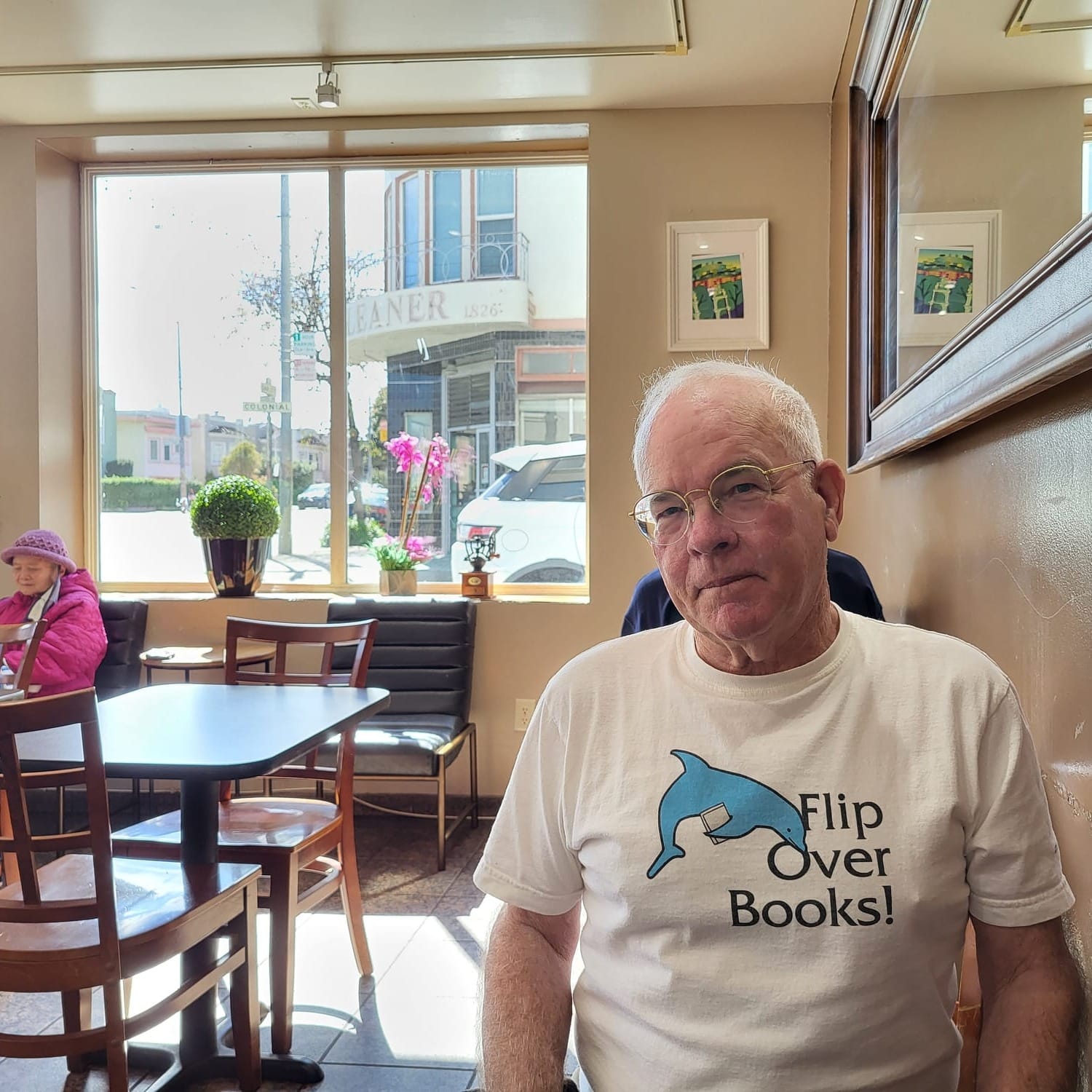 Man with "Flip Over Books!" shirt in a cafe.