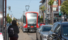 A woman waits for a streetcar stuck in traffic.