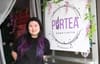 Woman by sign that reads "Purtea".