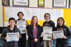 Students with their instructor holding newspapers