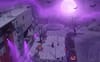 A Halloween-themed digital illustration of Unity Plaza with a purple sky, full moon, bats, glowing jack o'lanterns and purple-lit apartments.