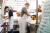 Restaurant workers prepare meats.