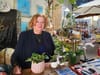 Woman at desk with lots of plants.
