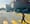 Woman crosses the street in front of a big box store space.