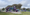 A front-facing view of Crocker-Amazon Playground’s blue play structure with purple slides near grass.